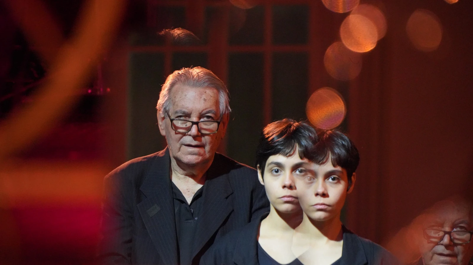 Imagem de Interrogação, um diálogo temporal, com dois personagens e reflexos.