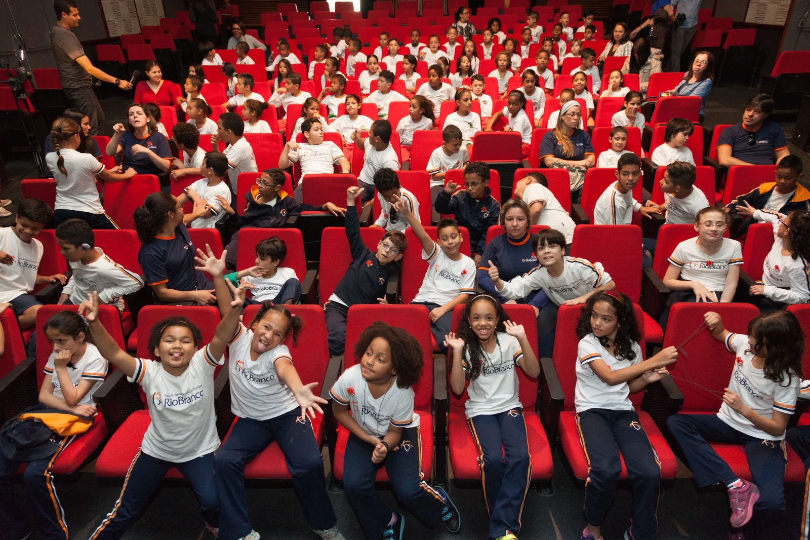 Crianças e educadores na plateia de uma atividade do projeto Leva ao Teatro.